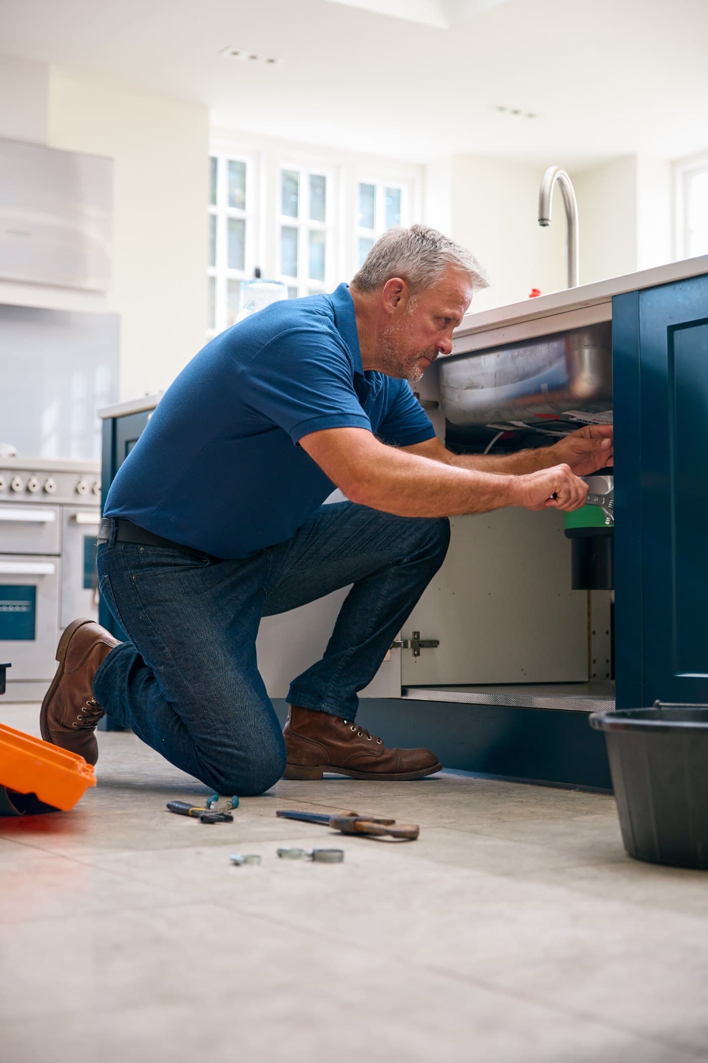 A tradesperson mid-job with a phone in hand.